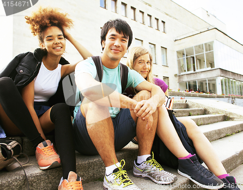 Image of cute group of teenages at the building of university with books 