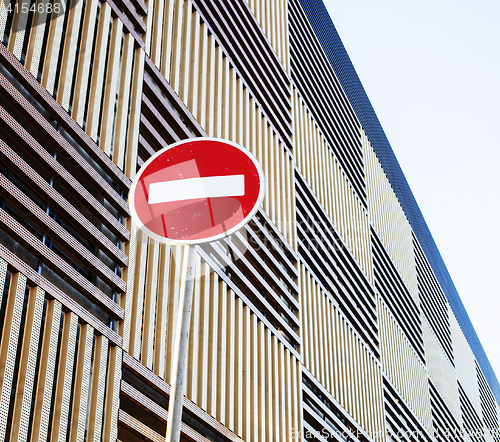 Image of stop sign near new parking building, empty street nobody concept