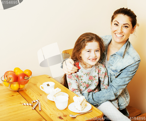 Image of young mother with daughter on kitchen drinking tea together hugg