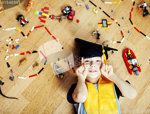Image of little cute preschooler boy among toys lego at home in graduate 