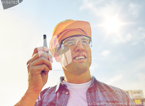 Image of close up of builder in hardhat with walkie talkie