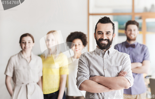 Image of happy young man over creative team in office