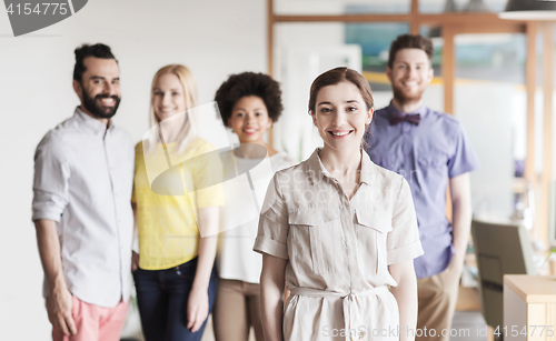 Image of happy young woman over creative team in office