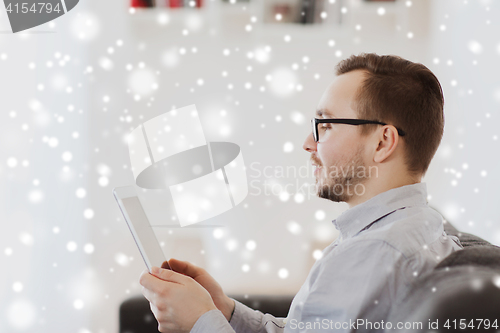 Image of man with tablet pc at home over snow