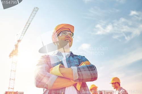 Image of group of smiling builders in hardhats outdoors