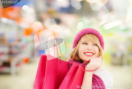 Image of woman in hat and scarf shopping at supermarket