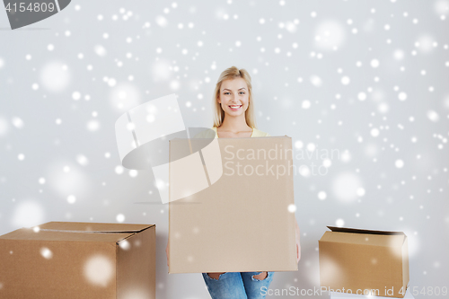 Image of smiling young woman with cardboard box at home