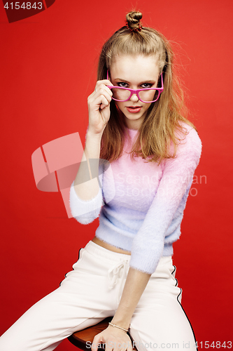 Image of young pretty emitonal posing teenage girl on bright red background, happy smiling lifestyle people concept