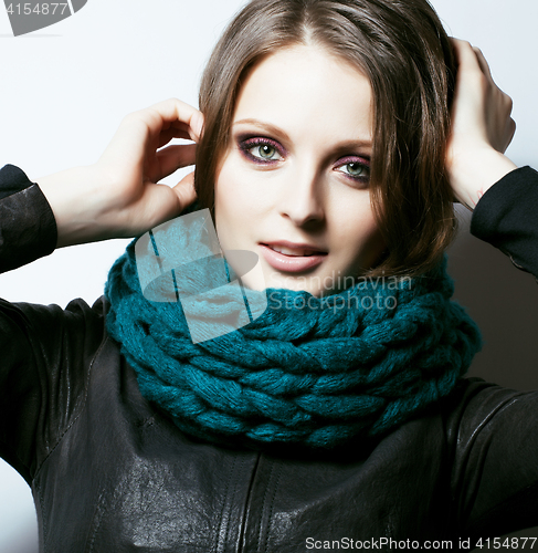 Image of young pretty real woman in sweater and scarf all over her face s