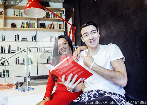 Image of couple students in univercity library, looking book, preparing t