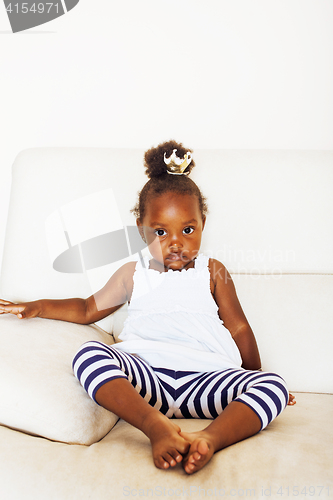 Image of little pretty african american girl sitting in white chair weari