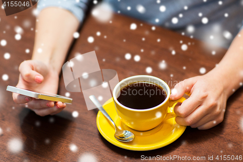 Image of woman with smartphone drinking coffee at cafe