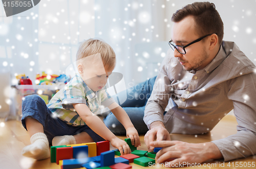 Image of father and son playing with toy blocks at home