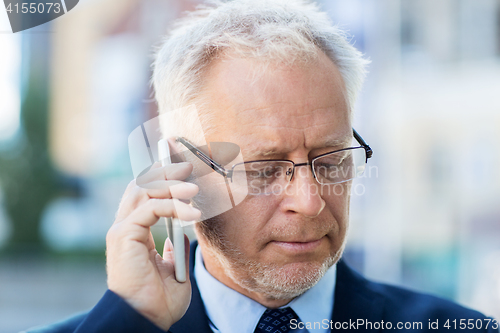 Image of close up of old businessman calling on smartphone