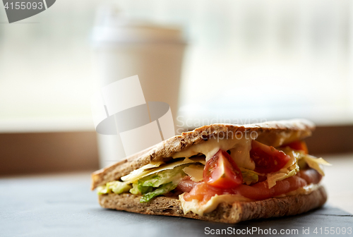 Image of salmon panini sandwich on stone plate at cafe