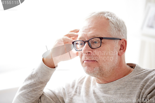 Image of close up of senior man in glasses thinking