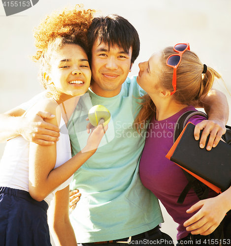 Image of cute group of teenages at the building of university with books huggings, diversity nations