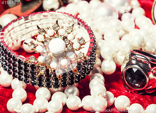 Image of lot of jewellery close up in red velvet box, ring bracelet