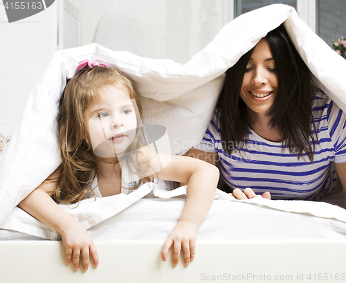 Image of Portrait of mother and daughter playing in bed, lifestyle people concept