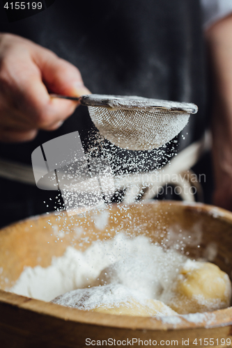 Image of Person covering pastry with flour