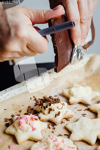 Image of Cook decorating cookies with chocolate