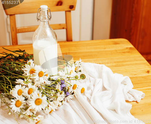 Image of Simply stylish wooden kitchen with bottle of milk and glass on t