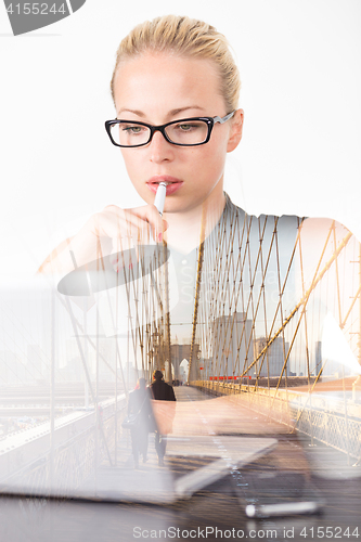 Image of Of thoughts business woman in office, day dreaming.