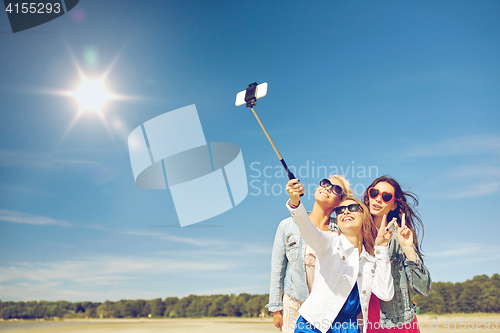 Image of group of smiling women taking selfie on beach