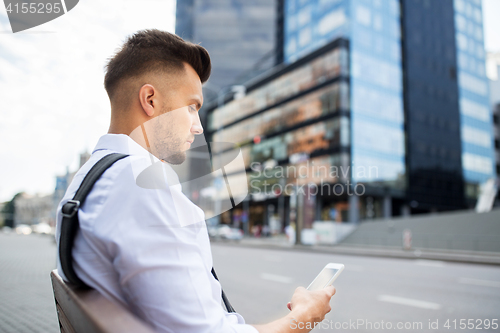 Image of man with smartphone and bicycle in city