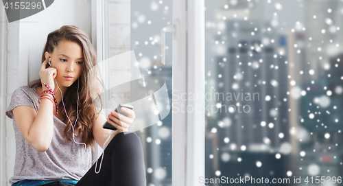 Image of teenage girl with smartphone and earphones