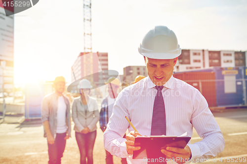 Image of happy builders and architect at construction site