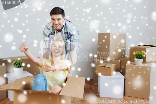 Image of happy couple having fun with boxes at new home