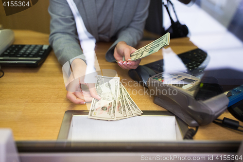 Image of clerk giving cash money to customer at bank office