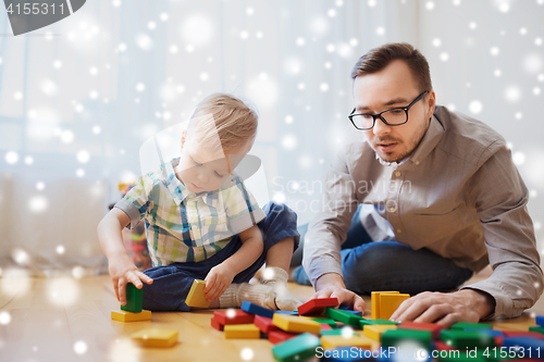 Image of father and son playing with toy blocks at home