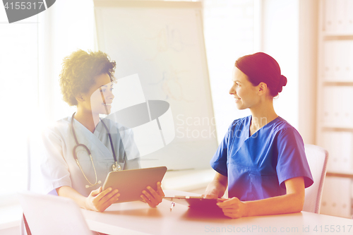 Image of happy doctors with tablet pc meeting at hospital