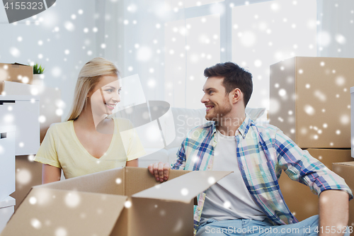 Image of smiling couple with big boxes moving to new home