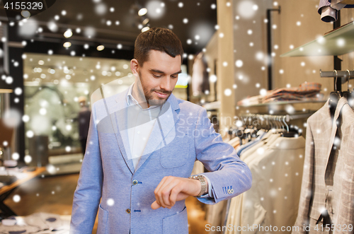 Image of happy man in jacket with watch at clothing store