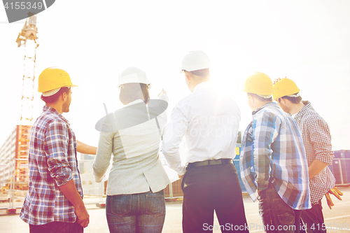 Image of group of builders and architects at building site