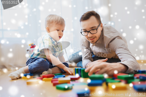 Image of father and son playing with toy blocks at home