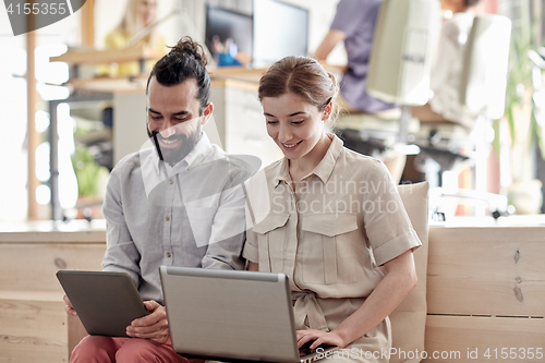 Image of creative team with tablet pc and laptop in office