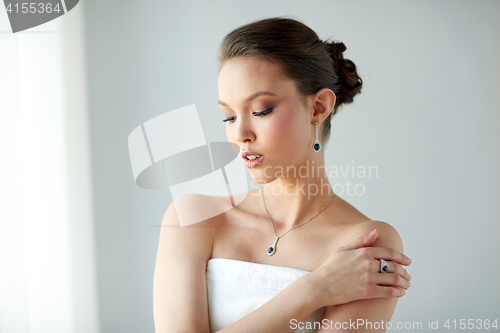 Image of beautiful woman with earring, ring and pendant