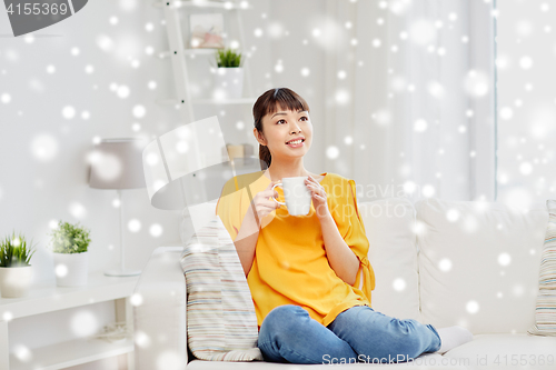 Image of happy asian woman drinking from tea cup