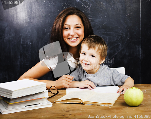 Image of little cute boy with teacher in classroom