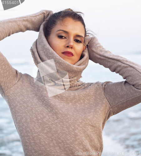 Image of young pretty woman in sweater at seacoast walking relaxing