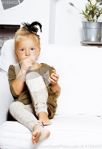 Image of little cute blonde norwegian girl playing at home with pillows