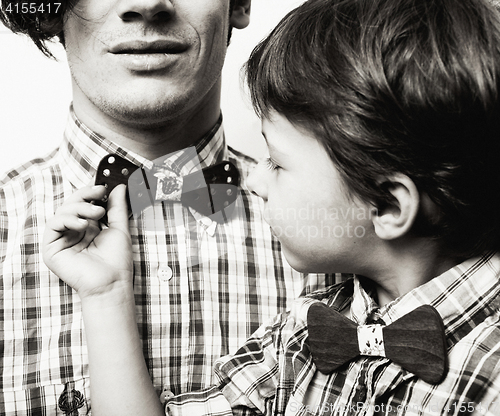 Image of father with son in bowties on white background, casual look fami