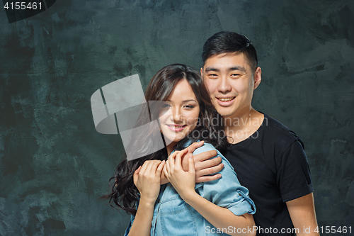 Image of Portrait of smiling Korean couple on a gray