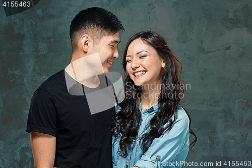 Image of Portrait of smiling Korean couple on a gray