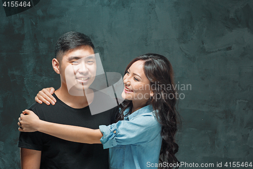Image of Portrait of smiling Korean couple on a gray