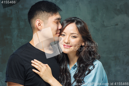 Image of Portrait of smiling Korean couple on a gray